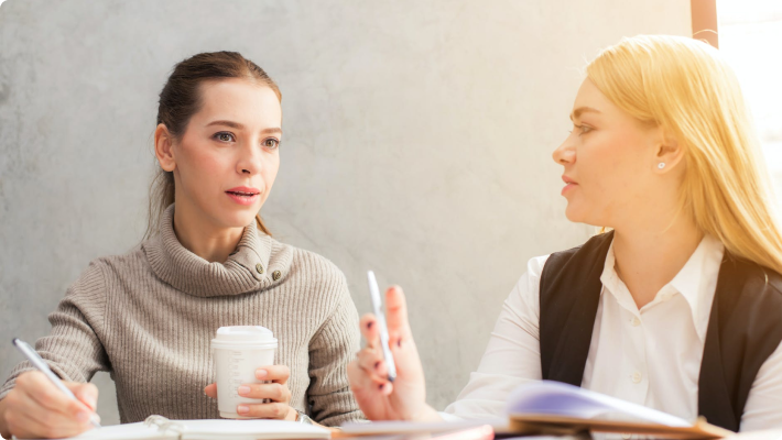 two women talking over coffee